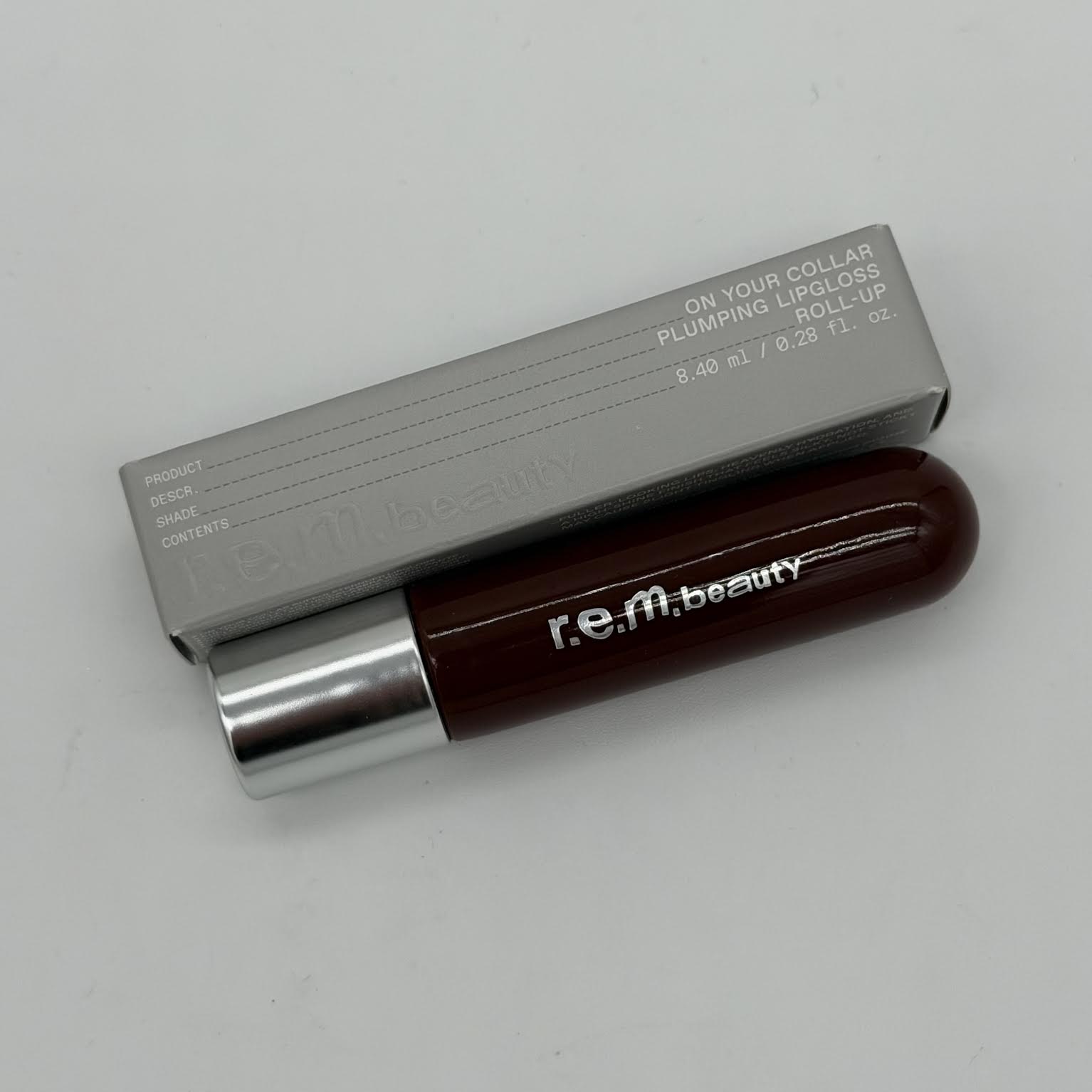 WHOLESALE R.E.M. BEAUTY ON YOUR COLLAR PLUMPING LIP GLOSS 0.28 OZ - ROLL-UP - 42 PIECE LOT